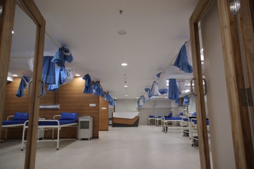 Spacious hospital ward at Care and Cure Multispeciality Hospital with multiple patient beds and privacy curtains