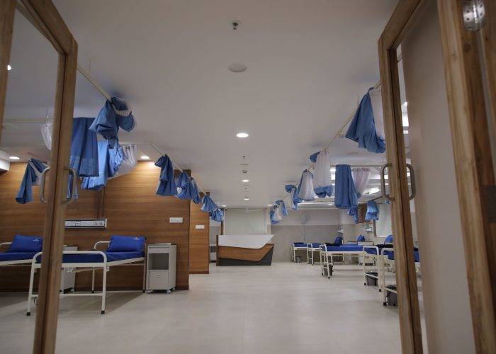 Spacious hospital ward at Care and Cure Multispeciality Hospital with multiple patient beds and privacy curtains