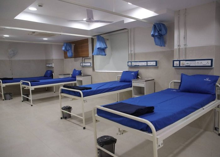 Spacious hospital ward at Care and Cure Multispeciality Hospital with multiple patient beds and privacy curtains
