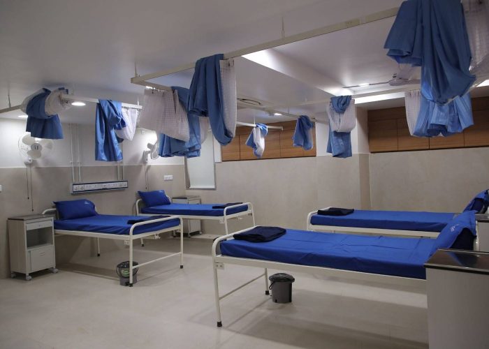Spacious hospital ward at Care and Cure Multispeciality Hospital with multiple patient beds and privacy curtains side view